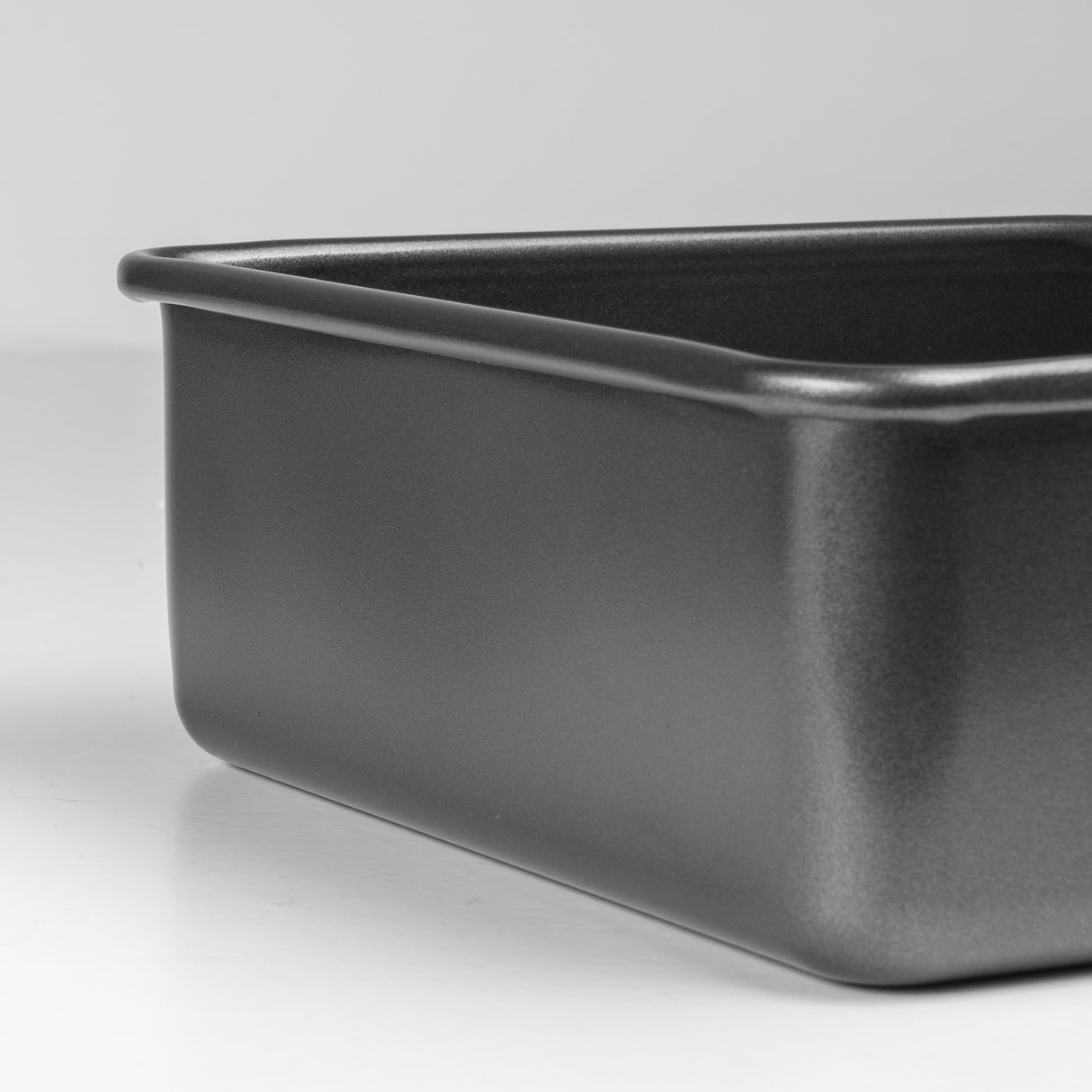 Black deep square baking pan on a light grey background