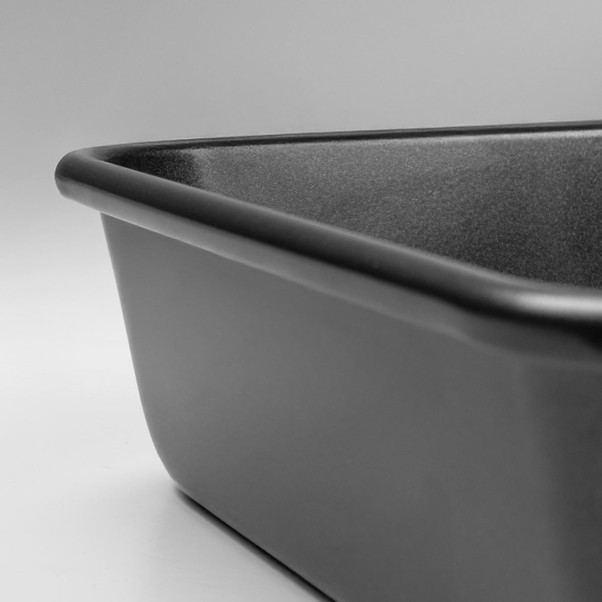 Close-up of a black rectangular roasting tin on a neutral background
