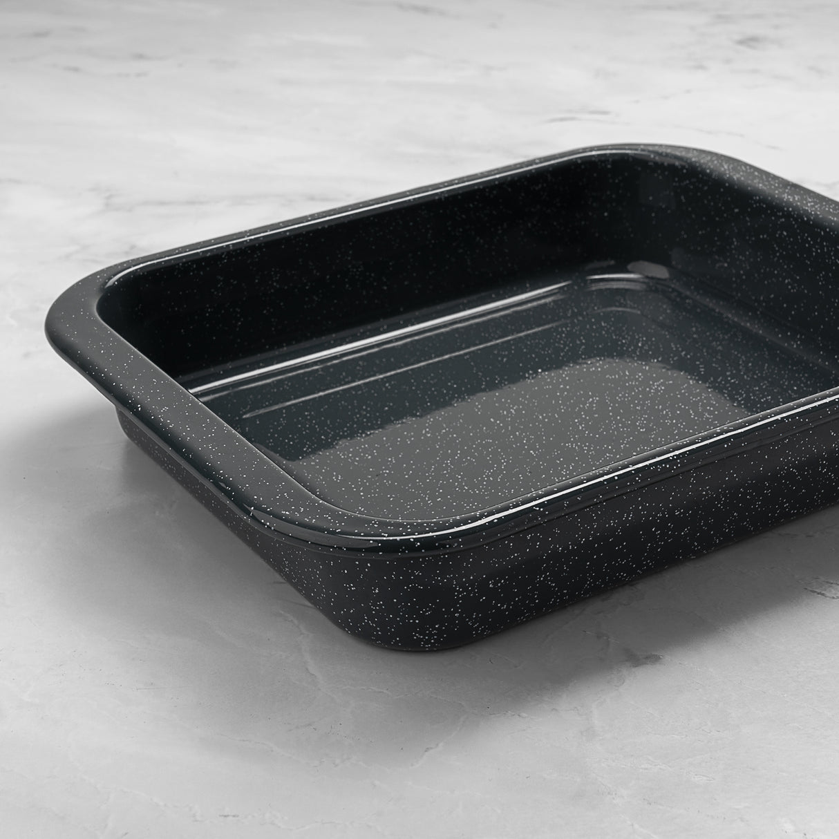 Grey enamel speckled rectangular baking tray on a light grey surface