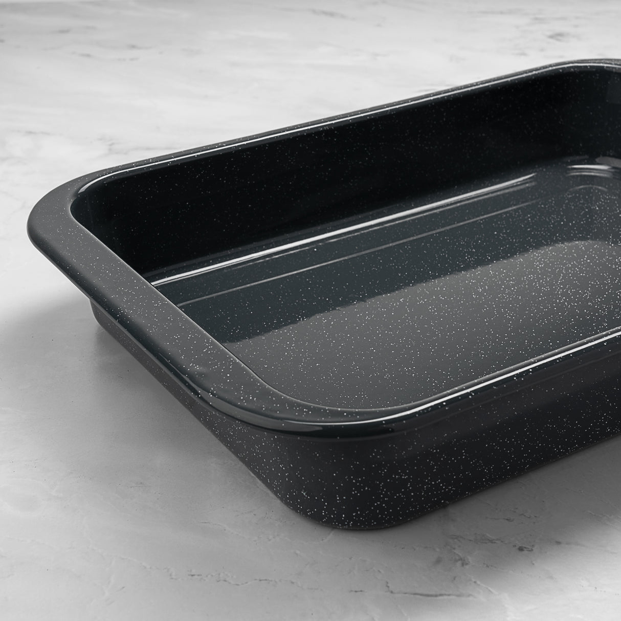 Grey enamel speckled baking tray on a light grey surface