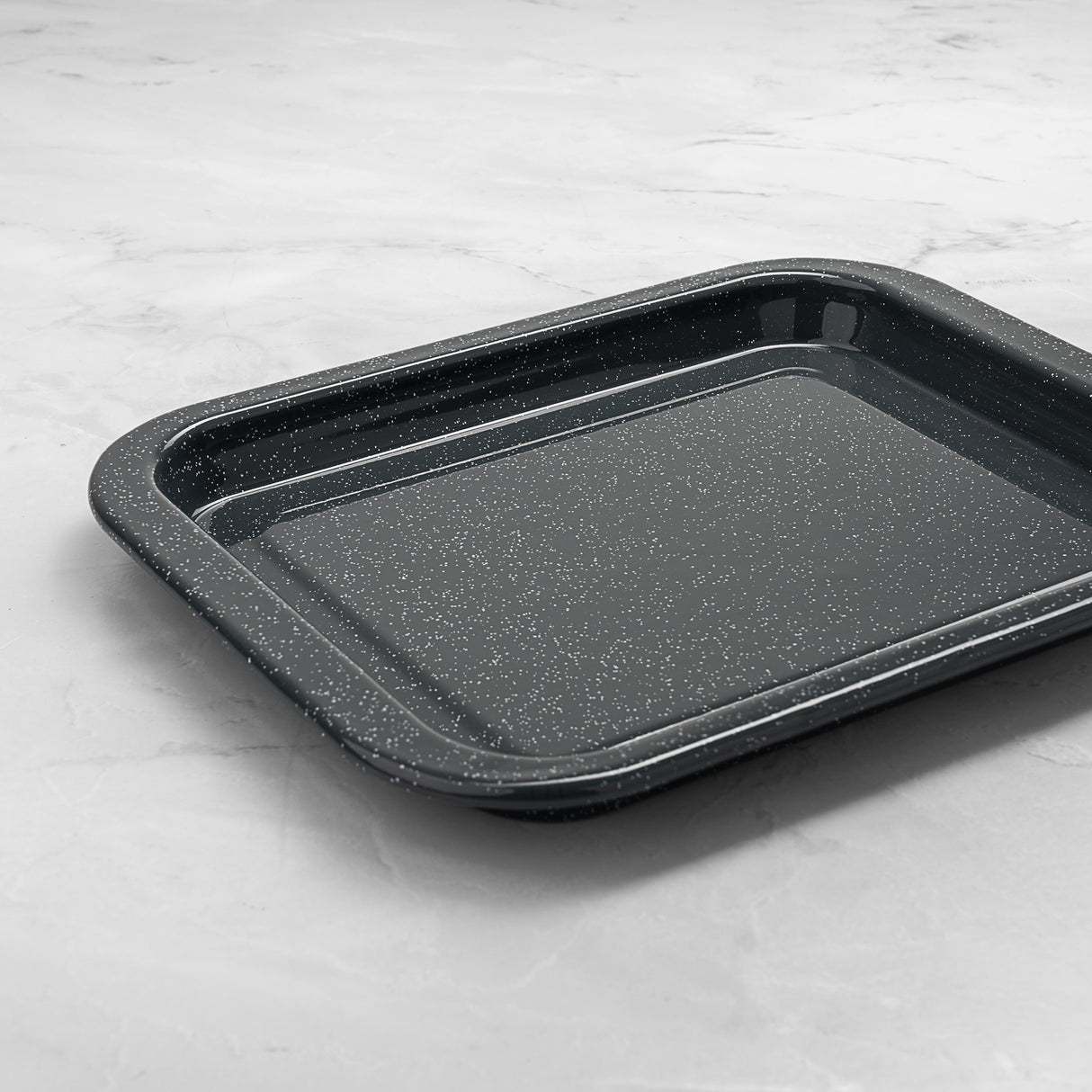 Grey speckled baking tray on a light grey marble surface