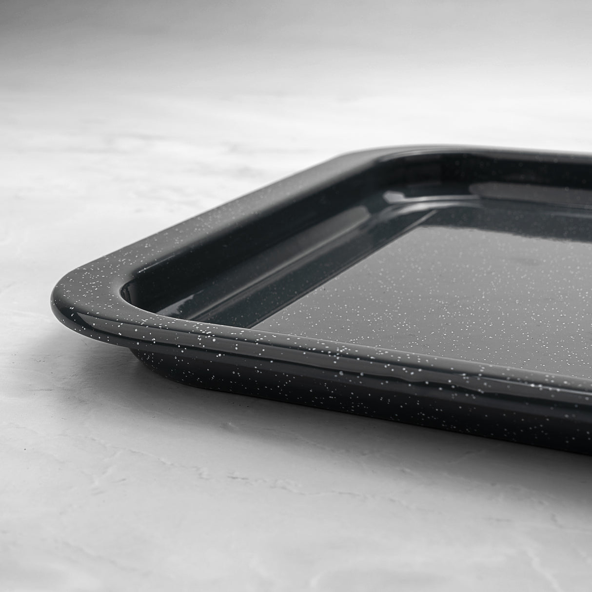 Grey speckled baking tray on a light grey background