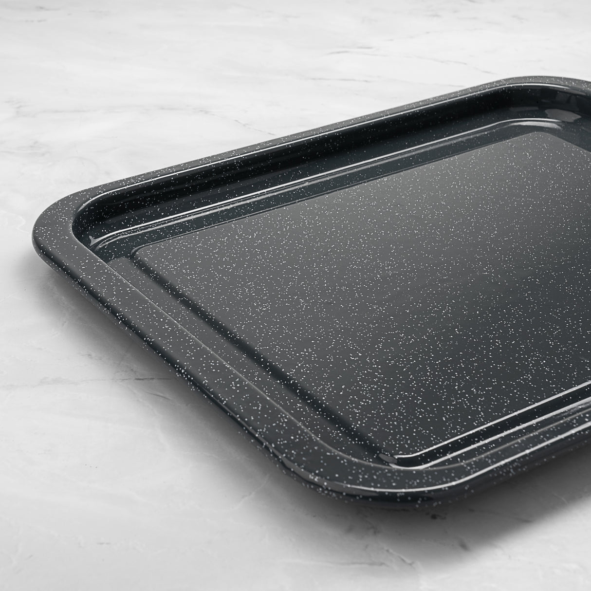 Grey speckled baking tray on a light grey surface