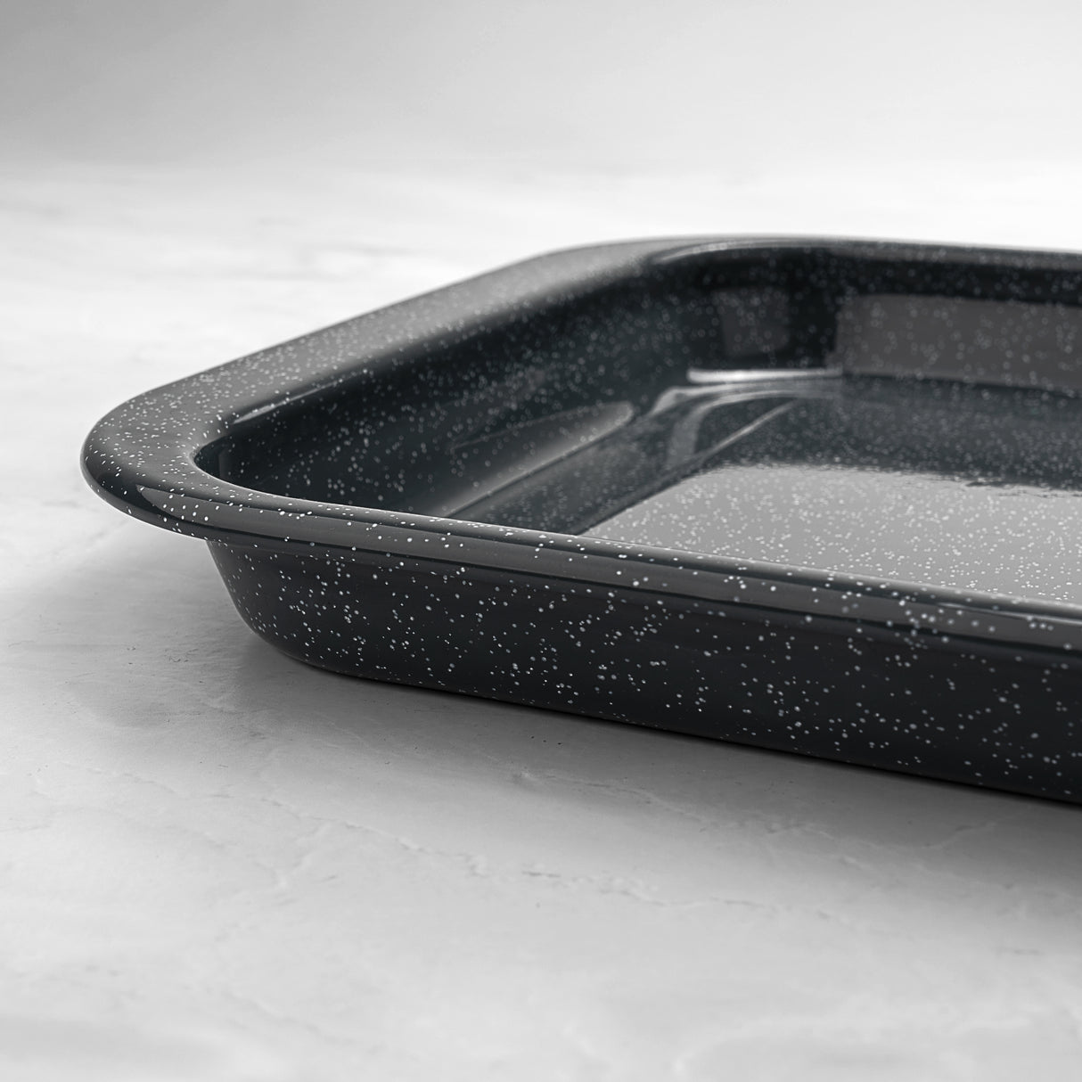 Grey speckled baking tray on a light grey background