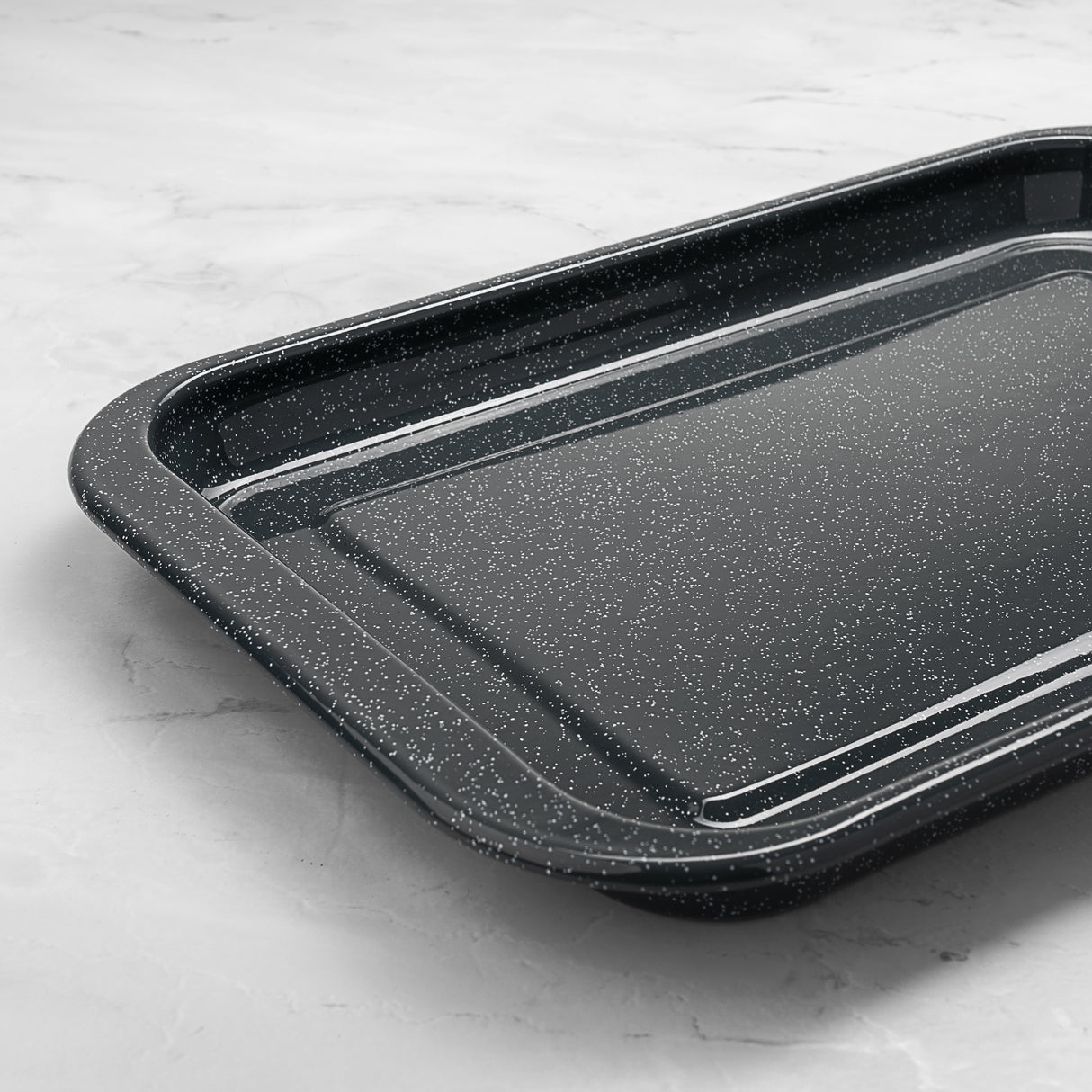 Grey speckled baking tray on a light grey surface