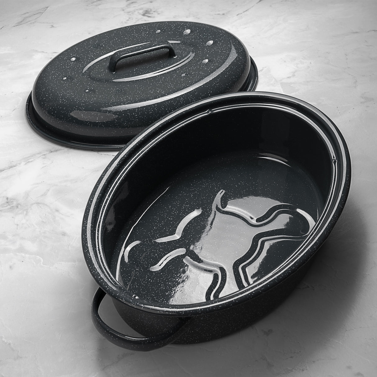 Grey speckled roasting pan with lid on a light grey surface