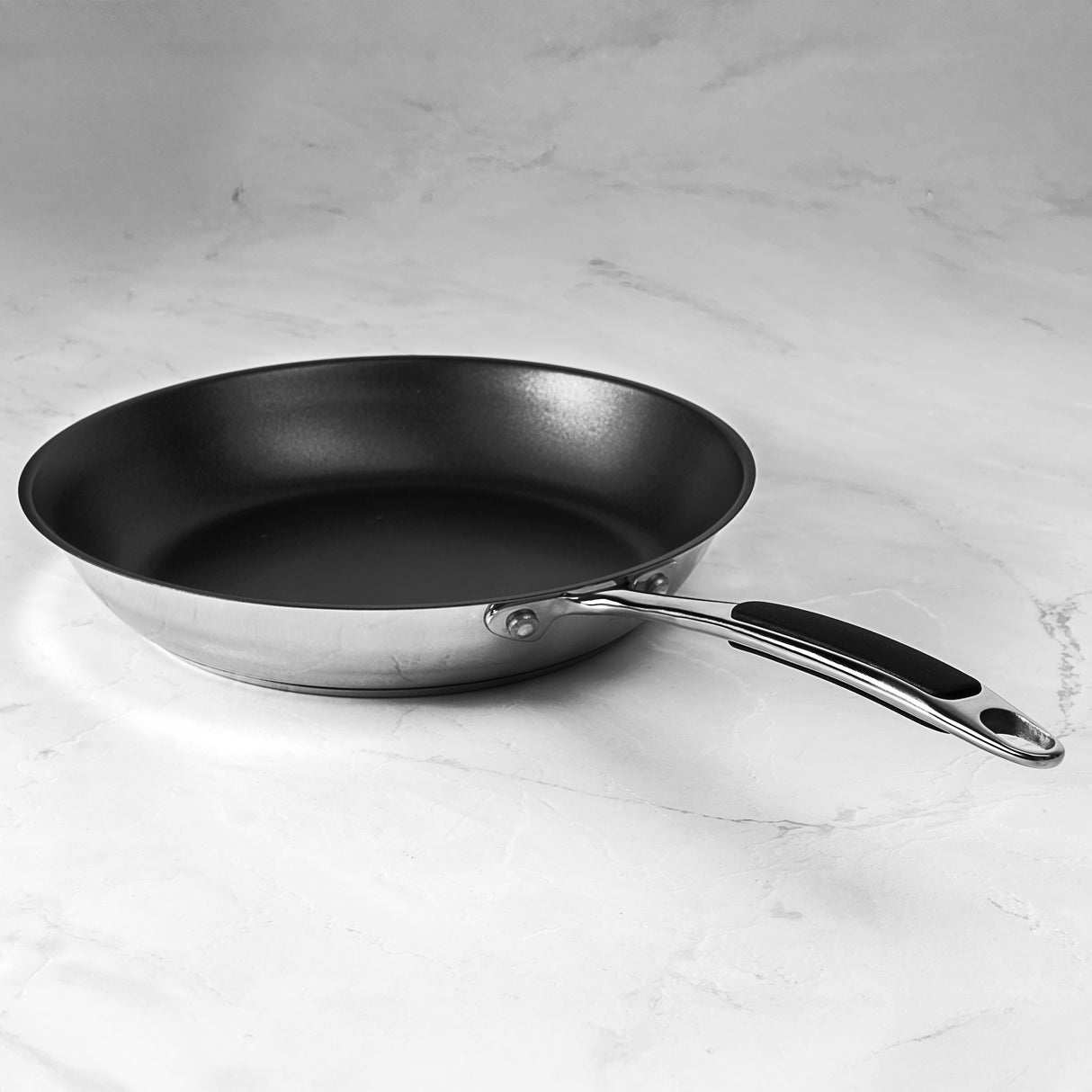 Black ProChef frying pan with a silver handle on a light gray marble surface