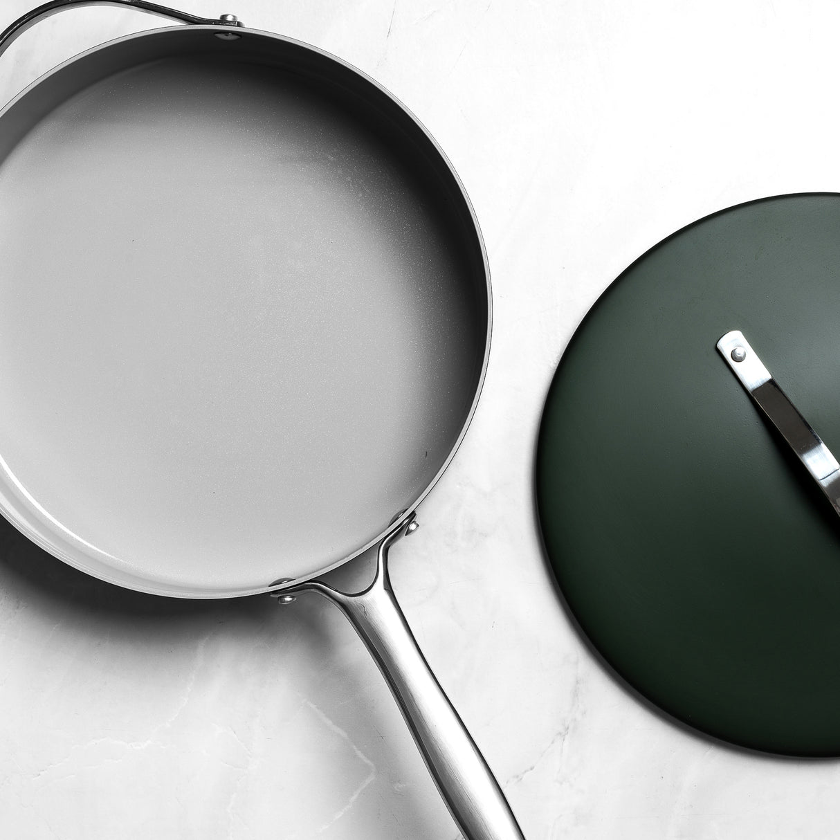 Frying pan with a lid on a light gray background