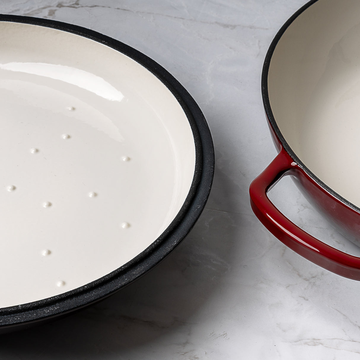 ProChef red cast iron casserole dish with matching lid, shown open to display white enamel interior and self-basting lid underside with raised condensation dots, set on a grey marble surface.