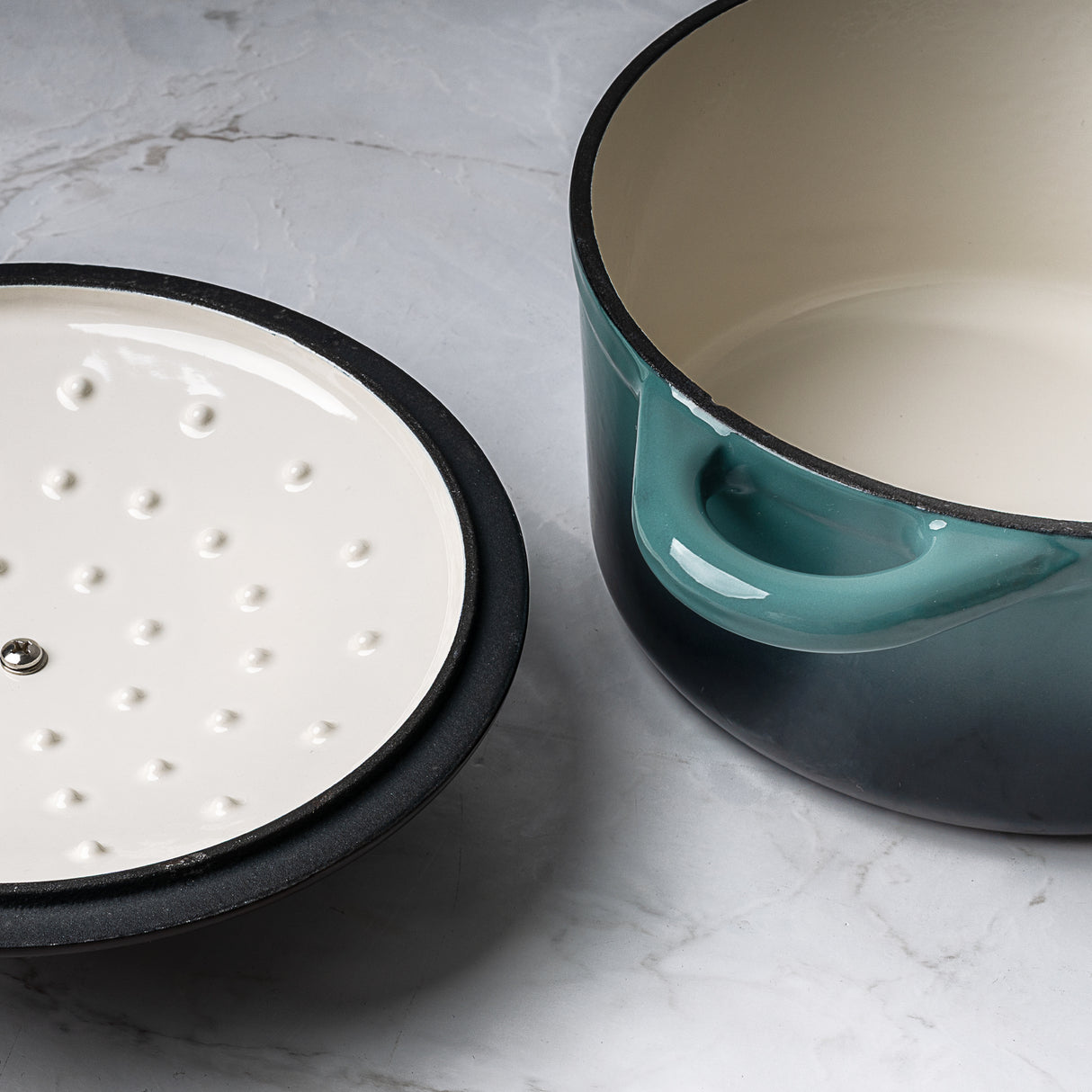 ProChef teal gradient cast iron casserole dish with white enamel interior, shown beside its matching lid with white underside featuring raised self-basting dots.