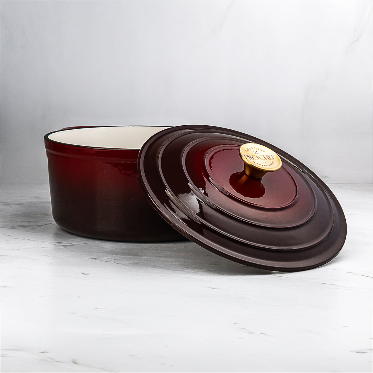ProChef deep red cast iron casserole pot featuring a lid with gold handle on a white surface