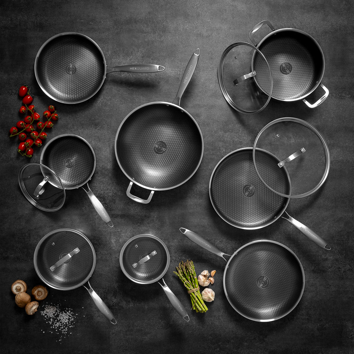 Top down shot of a set of silver HexGuard cookware with lids on a dark surface