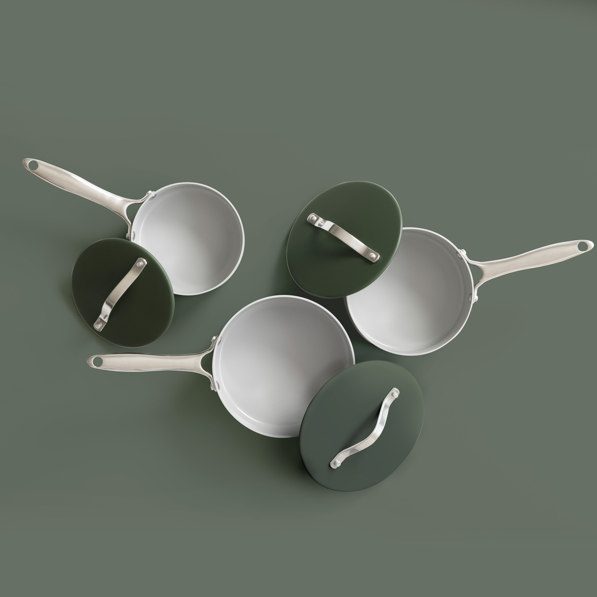 Top view of three ProChef green ceramic-coated aluminium saucepans with matching green lids and stainless steel handles, arranged on a muted green background.