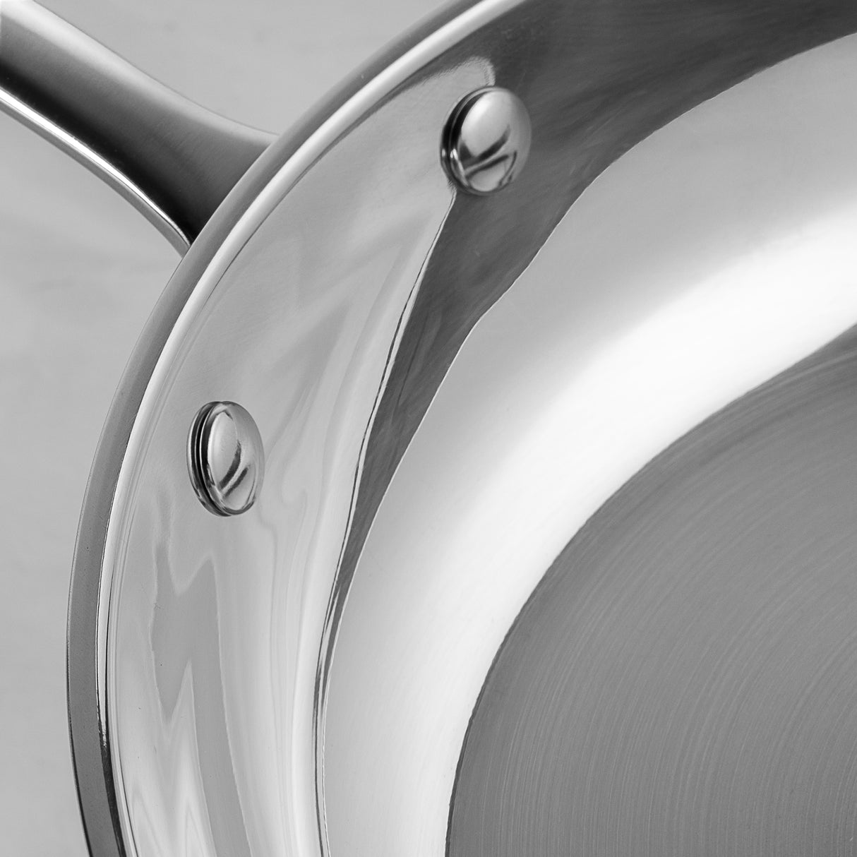 Close-up of ProChef stainless steel frying pan interior showing riveted stainless steel handle attachment and mirrored steel cooking surface.