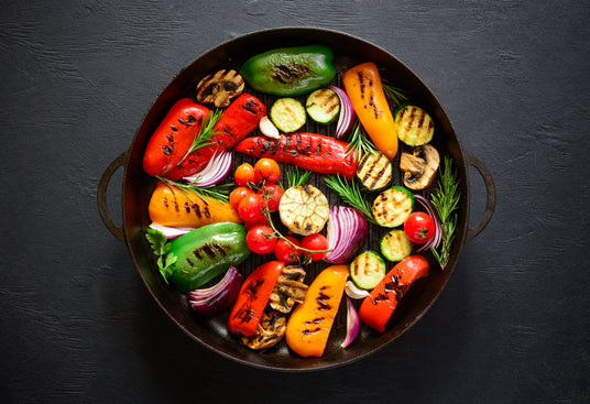 Assorted grilled vegetables in a pan on a dark background