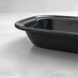 Close-up of a rectangular grey speckled enamel pie dish, showing deep sides and smooth enamel finish for oven baking.