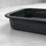 Side view of a rectangular grey speckled enamel roasting dish on a marble surface.