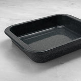 Grey enamel speckled rectangular baking tray on a light grey surface