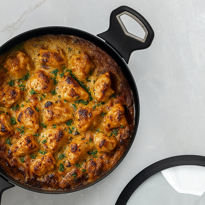 Skillet with creamy chicken and dumplings on a light gray background