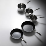 Set of ProChef stainless steel cookware including pots and pans on a gray background