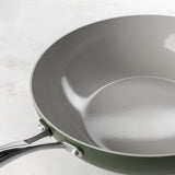Close-up of ProChef green ceramic-coated aluminium wok with silver interior and stainless steel handle.