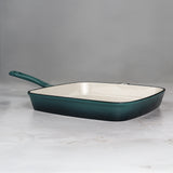 Teal cast iron frying pan on a grey background