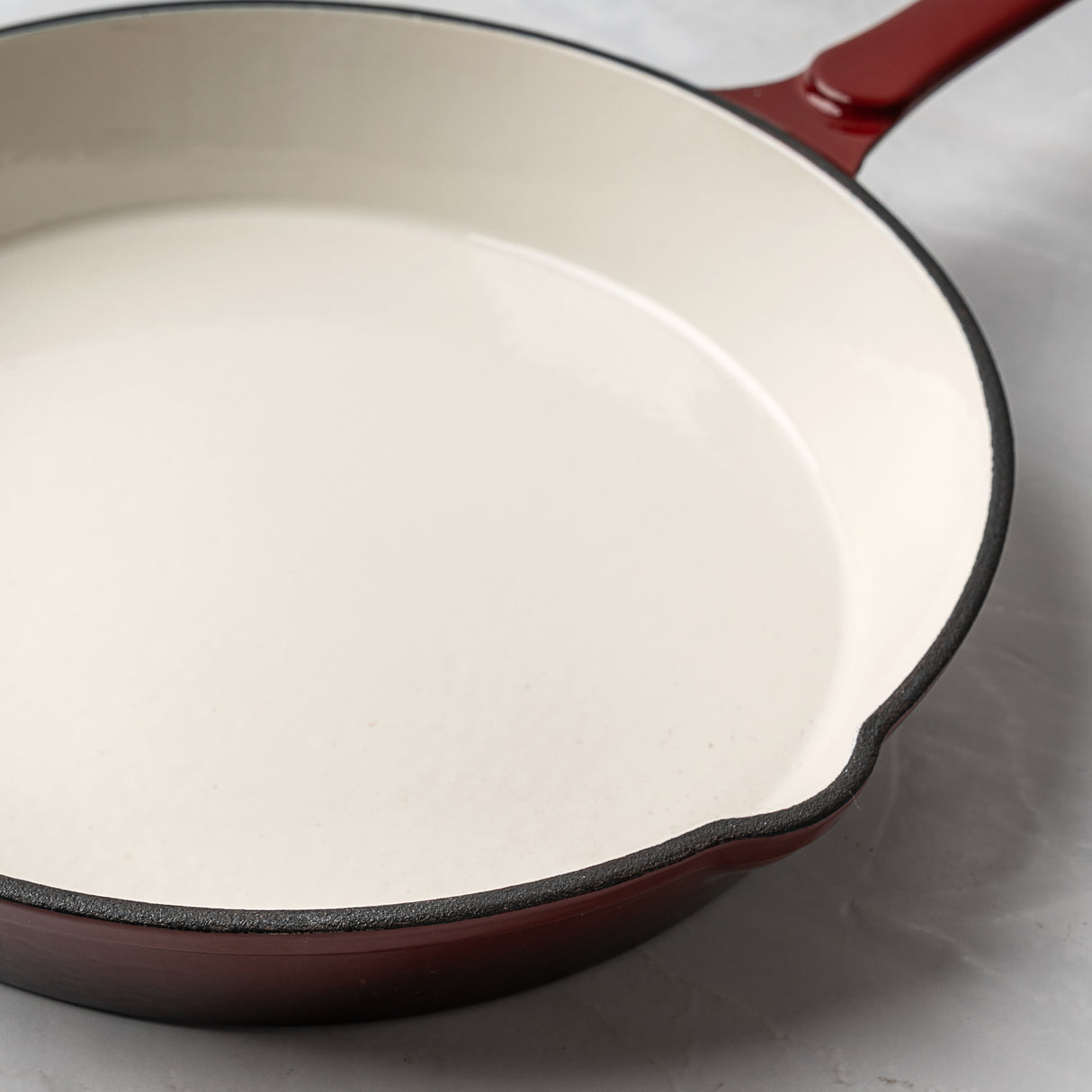 Red enameled cast iron skillet on a light gray background