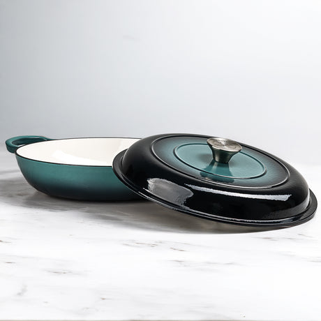 ProChef shallow cast iron casserole in teal with white enamel interior, shown with matching black-and-teal lid featuring a silver knob.