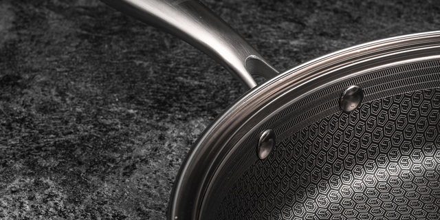 Close-up of a saute pan with a textured surface on a dark background