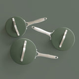 Top view of three ProChef green ceramic-coated aluminium saucepans with matching lids and polished stainless steel handles, arranged on a muted green background.