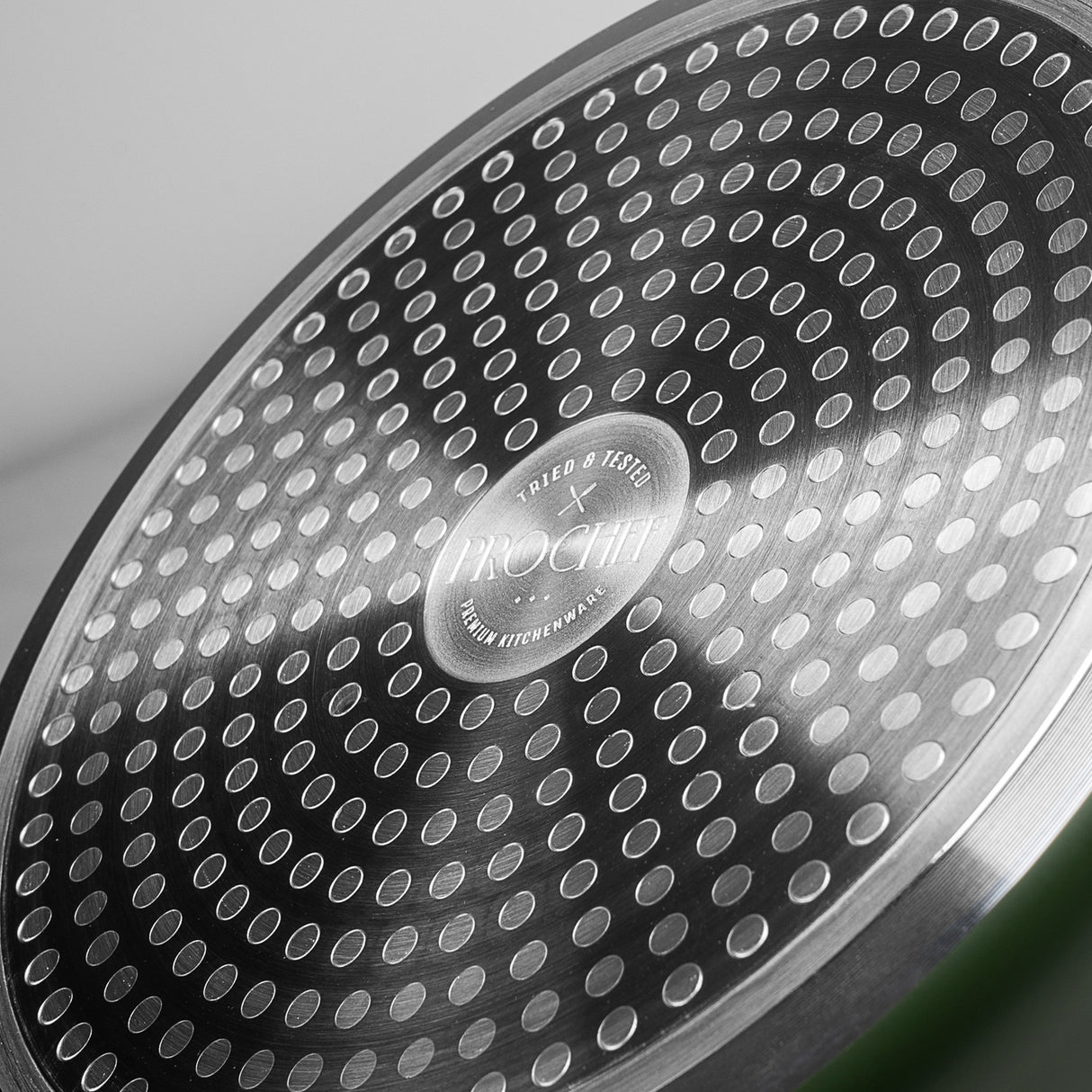 Close-up of the ProChef cookware base, showing the stainless steel induction-compatible bottom with circular dotted pattern and engraved ProChef logo at the center.