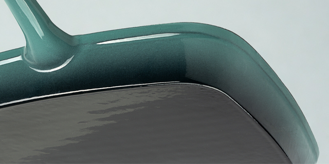 Close-up of the underside of a teal ProChef cast iron grill pan showing smooth enamel base and handle