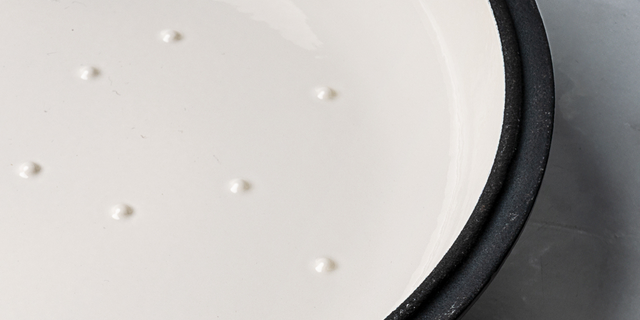 Close-up of ProChef cast iron casserole lid interior showing cream enamel surface with raised self-basting nodules.