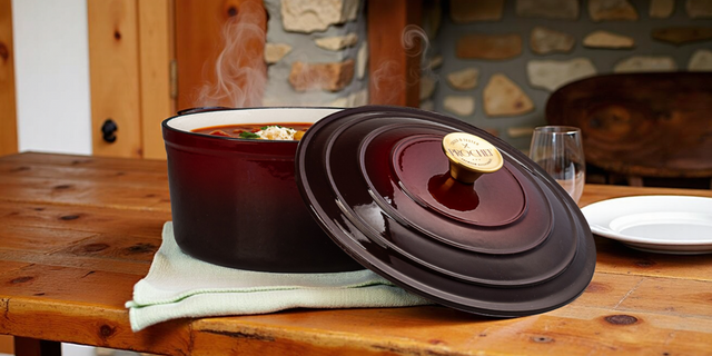 Maroon ceramic pot with lid on a wooden table