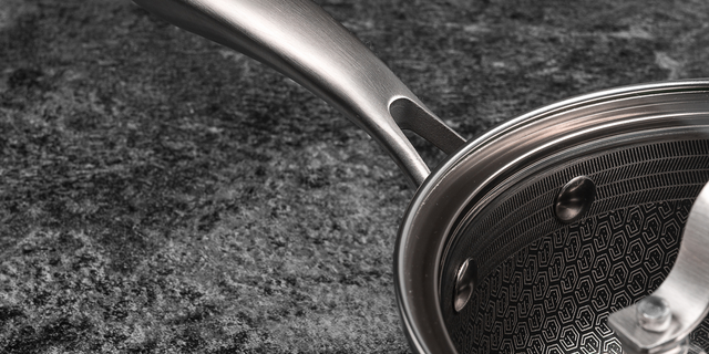 Close-up of a stainless steel saucepan on a dark surface