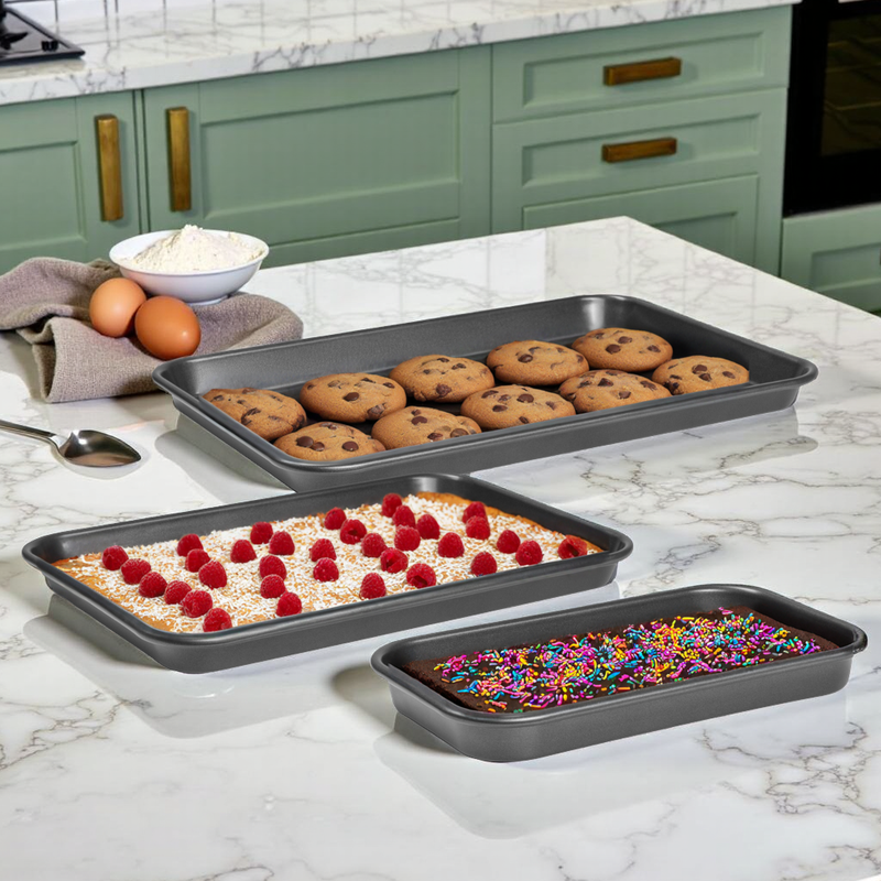 Three baking trays with different types of baked goods on a kitchen counter.