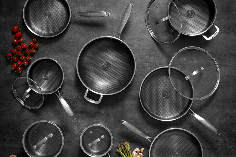 Top down shot of silver HexGuard cookware with lids on a dark surface