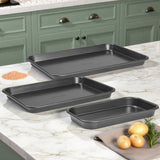 Set of three baking trays on a kitchen counter with green cabinets in the background.