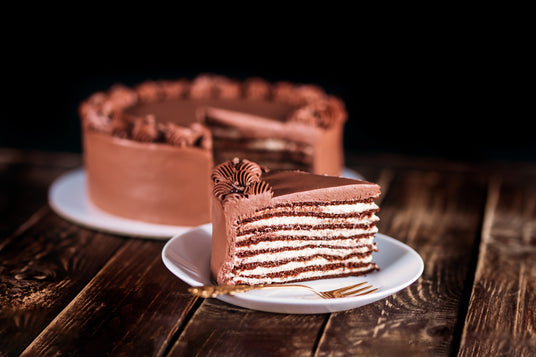 Chocolate cake with a slice on a plate on a wooden table