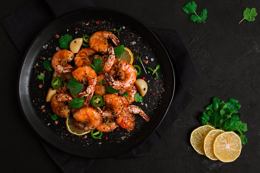 Plated shrimp dish with garnishes on a dark surface